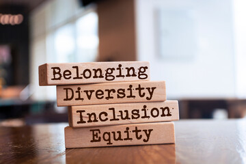 Equity, diversity, inclusion and belonging symbol. Wooden blocks with words 'equity, diversity, inclusion, belonging' on brown background. Diversity, equity, inclusion and belonging concept.