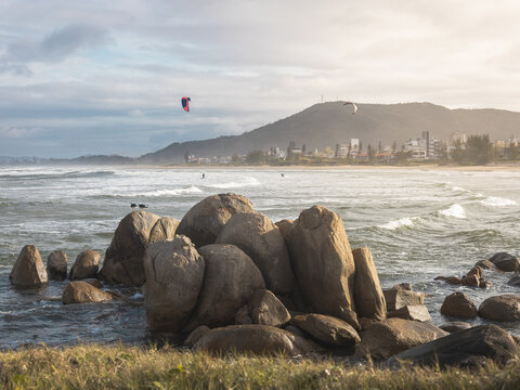 people kitesurfing and seagulls flying near the beach