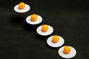 Still life with orange balls on white stands suspended in the air