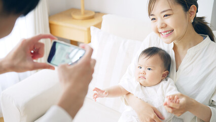 スマホで赤ちゃんを撮影するカップル