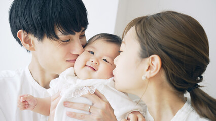 赤ちゃんにキスするカップル　子育てイメージ