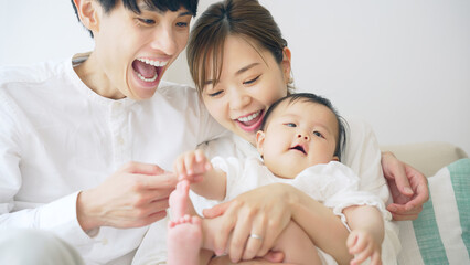 赤ちゃんを抱っこするカップル　子育てイメージ