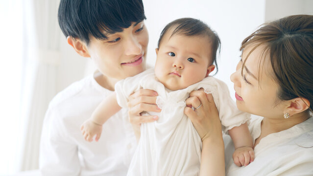 赤ちゃんを抱っこするカップル　子育てイメージ