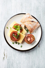 Sandwich with cheese and tomatoes. Bright wooden background. Top view. Copy space.	