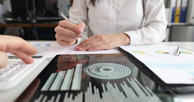Woman draws arrows on tablet with analytics