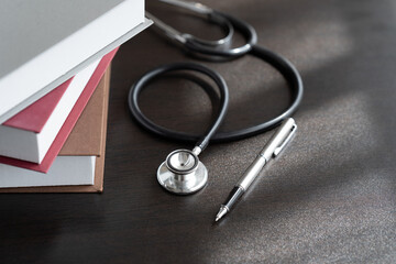 Medical student textbooks with pen and stethoscope on table. medical education medicine books and notes on the table.