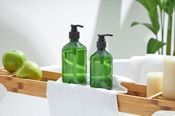 Cosmetics product and cotton towels, cottons pad with green plant on white table inside a bathroom background ceramic. Space for text