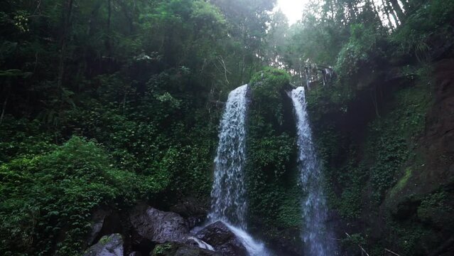Bottom up shot of falling waterfall in middle of deep forest named GRENJENGAN KEMBAR, Central Java