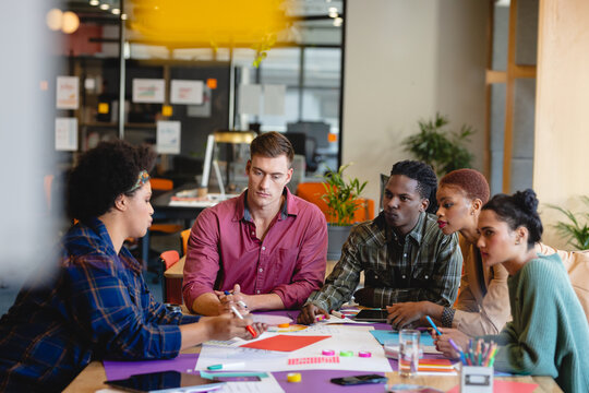 Multiracial design professionals brainstorming during meeting in studio office