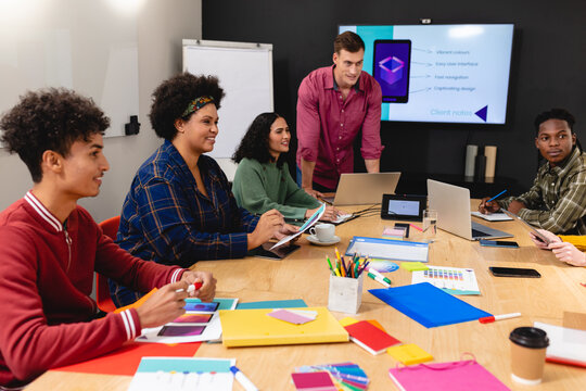 Multiracial app developers discussing ideas during meeting in office