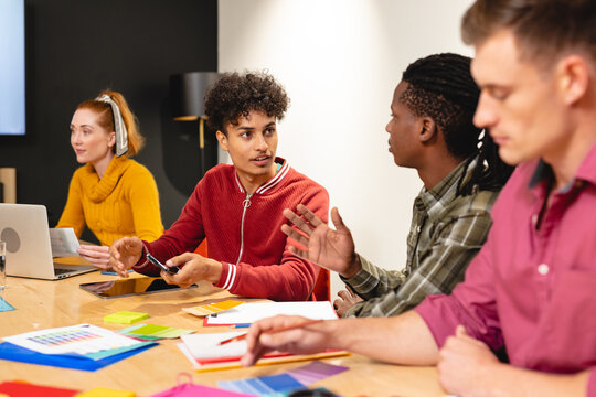 Biracial app developer discussing ideas with african american colleague in meeting at office