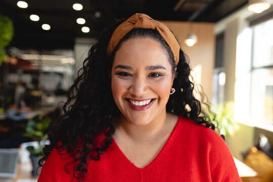 Portrait of happy biracial creative businesswoman in office