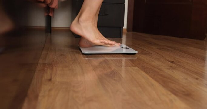 Women legs and weight measurement and joyful jumping
