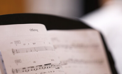 A close up view of the text or word 'Offering'. The christian hymn Offering musical score or sheet music with notes for the choir or musicians. - obrazy, fototapety, plakaty
