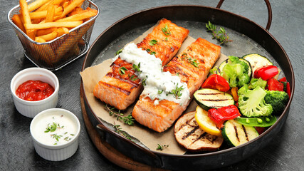 Salmon steak with vegetables on dark background.