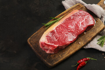 Fototapeta na wymiar Raw striploin beef steak dark background.