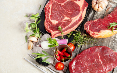 Variety of raw beef meat steaks for grilling.