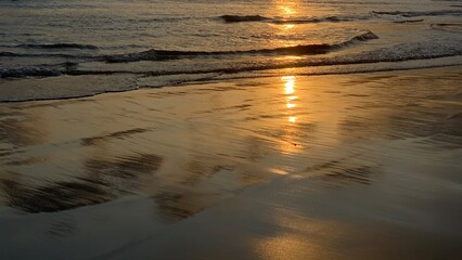 waves with dramatic sunset reflection with orange color on the surface