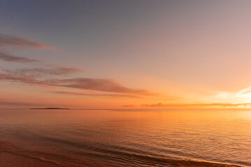 Fototapeta na wymiar Soft wave of morning ocean on sandy beach. Tranquil sunrise concept.