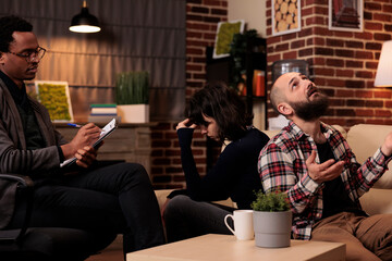 Couple with marriage issues fighting back to back at therapy session, asking for professional help and advice from therapist. Having conflict and arguing about relationship difficulties.