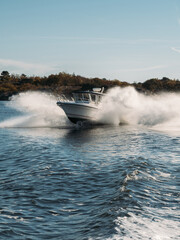Fototapeta premium Speedboat in navigation goes on the waves in deep blue water, sea view.