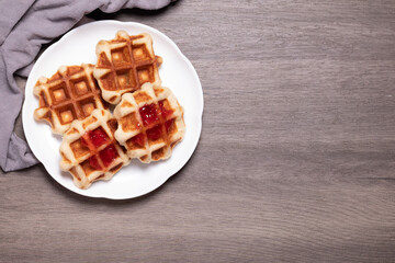 Four waffles in a white plate.and gray background.