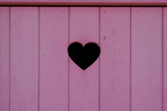 heart on wooden wall pink door background