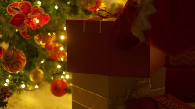 Closeup Of Santa's Hands Putting Down Gift Box Under The Christmas Tree, Slow Motion