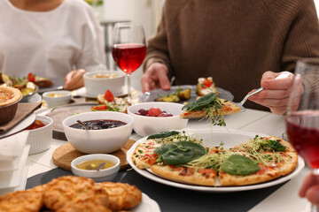Man taking slice of pizza during brunch at table indoors, closeup