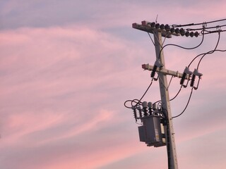 Electric poles and transformers, taken in the evening, pink sky