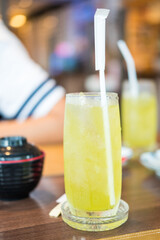 Iced green tea in tall glass with straw served for  customer at Japanese restaurant.