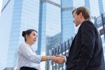 professional american businessman and young asian businesswoman handshake at corporate office after success in agreement on business and financial deal contact. business partnership.