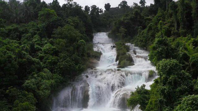 Beautiful waterfall in green forest, top view. Tropical Aliwagwag Falls in mountain jungle, Philippines, Mindanao. Waterfall in the tropical forest.