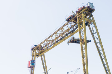 Professional yellow crane on a construction site. Clear sky. Workplace of blue-collar workers. High quality photo