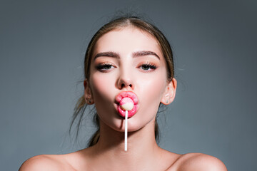 Sensual glamorous attractive lady licking yummy sugary lollypop with red lips. Girl sucks lollipop. Flirting sexy female pop art style. Portrait of sexy woman.