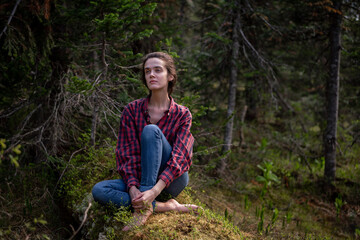 Attractive young girl in hipster clothes inforest on moss posing