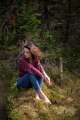 Naklejka premium Attractive young girl in hipster clothes inforest on moss posing
