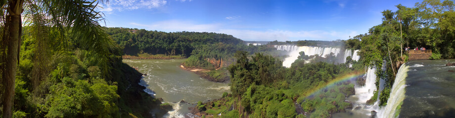 Large nature panorama of Iguacu (Iguazu) waterfall cascade on border of Brazil and Argentina. Amazing background of falls Cataratas in bright Sunny weather. Concept of travel. Copy space for site