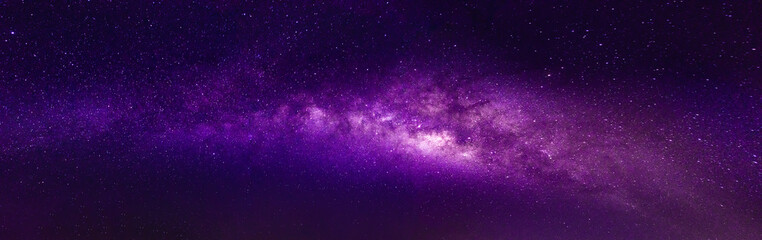 Milky way in the night sky and stars on dark background with noise and grain. Photo taken with long...