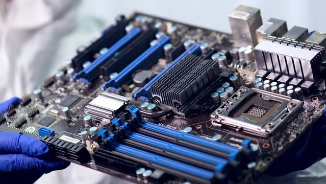 CPU in hands of a technician. The processor is being examined for apparent defects. In Modern Electronic Manufacturing Factory Design Engineer Holds Microchip . Close-up a New Generation Microchip.
