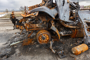 Fototapeta na wymiar Hostomel, Kyev region Ukraine - 09.04.2022: Burnt military vehicles of Russian soldiers on the bridge across the river. Cars after being hit by rockets, mines. Rusty cars. Charred car parts.