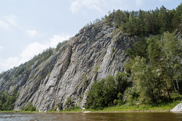 Rocky mountains descend into the river, mountainous terrain, taiga river, panorama mountain river,...