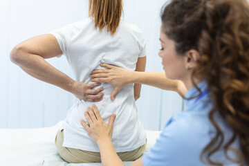 Physiotherapist doing healing treatment on womans back. Back pain patient, treatment, medical...