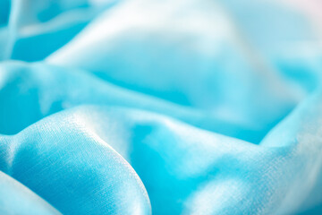 Satin fabric close up background and texture with place for text. Light blue chiffon or silk...