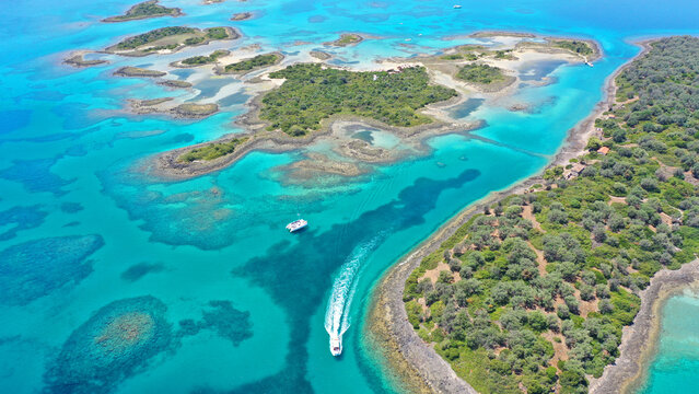 Aerial drone photo of tropical exotic volcanic island complex of Lihadonisia  forming a blue lagoon and small islet of Monolia with turquoise clear organised beach, north Evia island, Greece