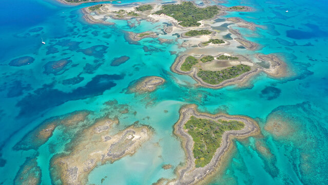 Aerial drone photo of tropical exotic volcanic island complex of Lihadonisia  forming a blue lagoon and small islet of Monolia with turquoise clear organised beach, north Evia island, Greece