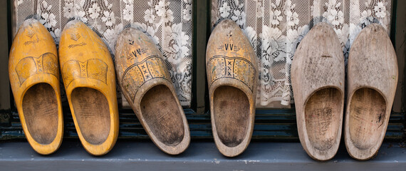Enkhuizen, Netherlands. June 2022. Old worn clogs against a background of paving stones.