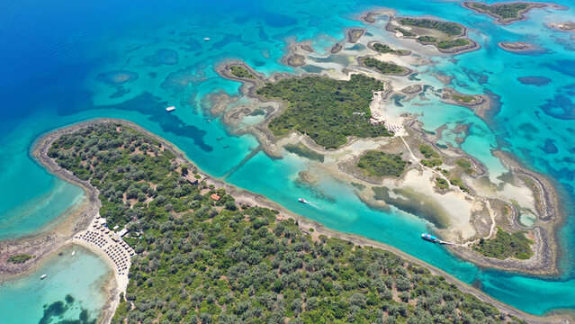 Aerial drone photo of tropical exotic volcanic island complex of Lihadonisia  forming a blue lagoon and small islet of Monolia with turquoise clear organised beach, north Evia island, Greece