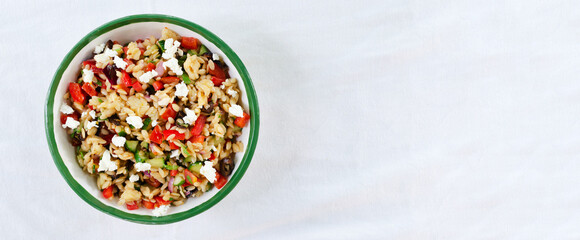 Banner. Multi-colored Orzo salad on the table. Tomatoes, cucumbers, feta cheese, olives, red...
