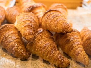 Tasty croissants on the tray sellin in the bakery shop.